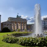 Discover the best accommodations in Berlin! Explore our guide on where to stay in Berlin for an unforgettable trip. Book now! - a fountain in the middle of a park with buildings in the background